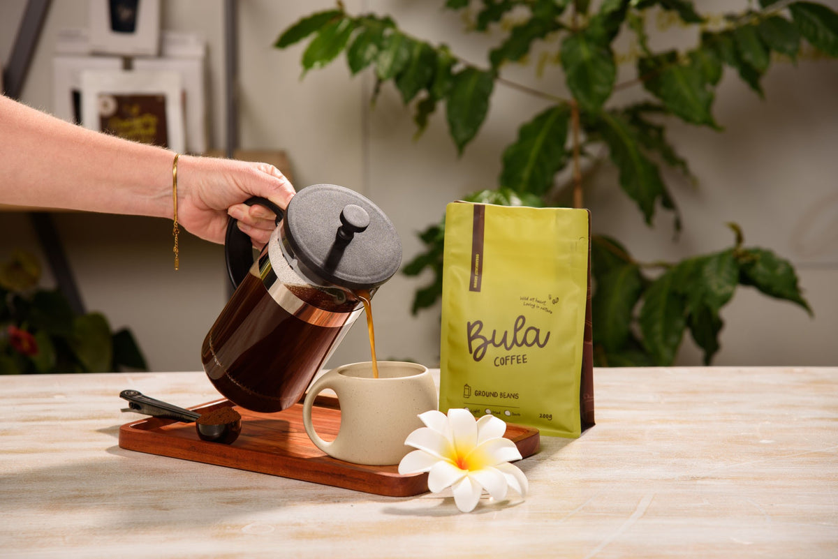 Pouring Bula Coffee from a French press into a mug