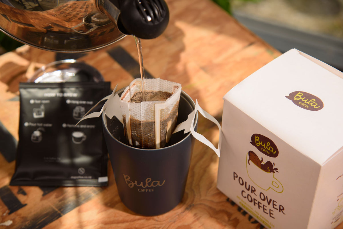 Hot water poured through a Bula pour over coffee bag into a navy Bula cup